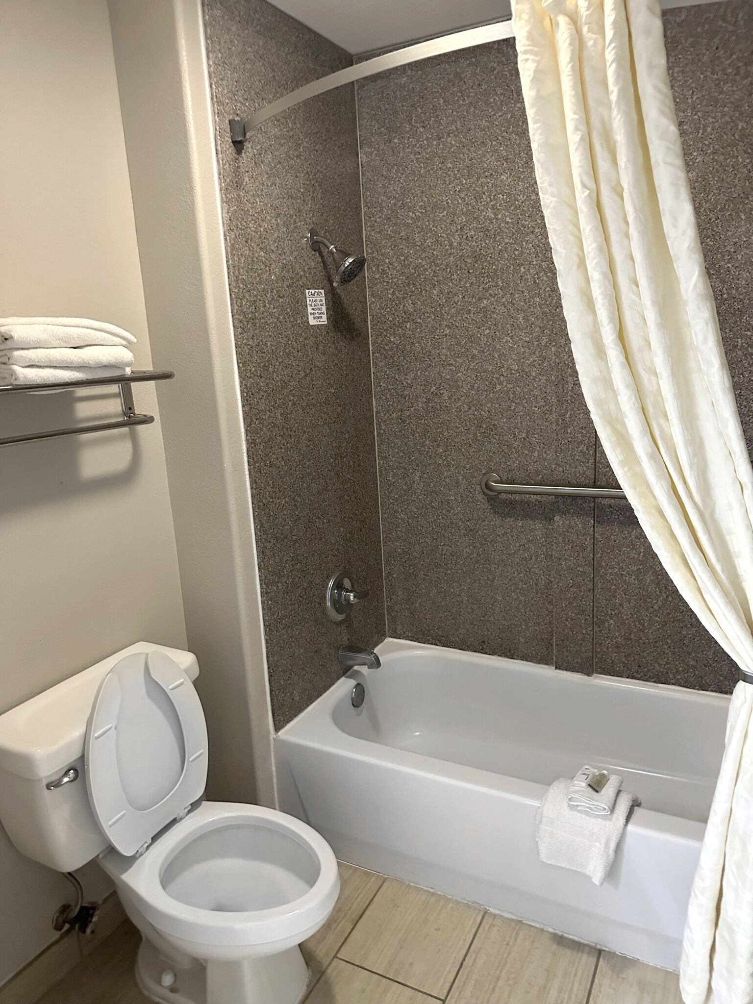 A bathroom with a toilet, a shower, and a bathtub.