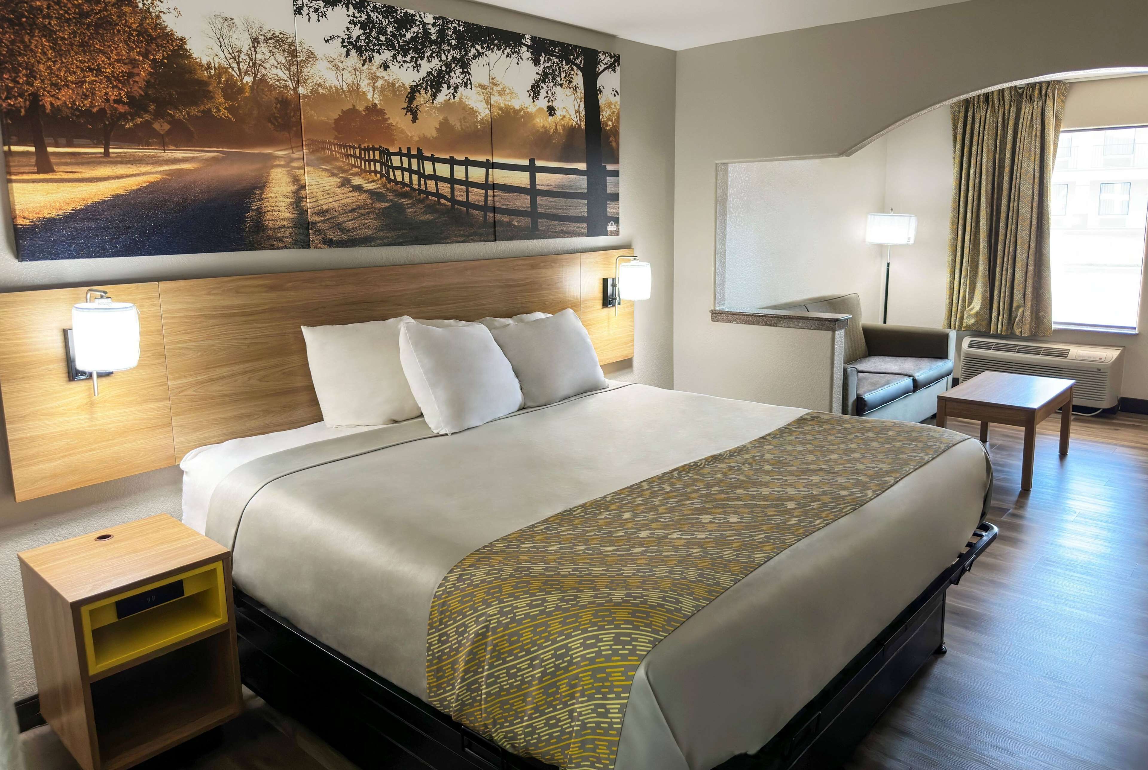 A hotel room with a large bed, bedside tables, a desk, and a chair.