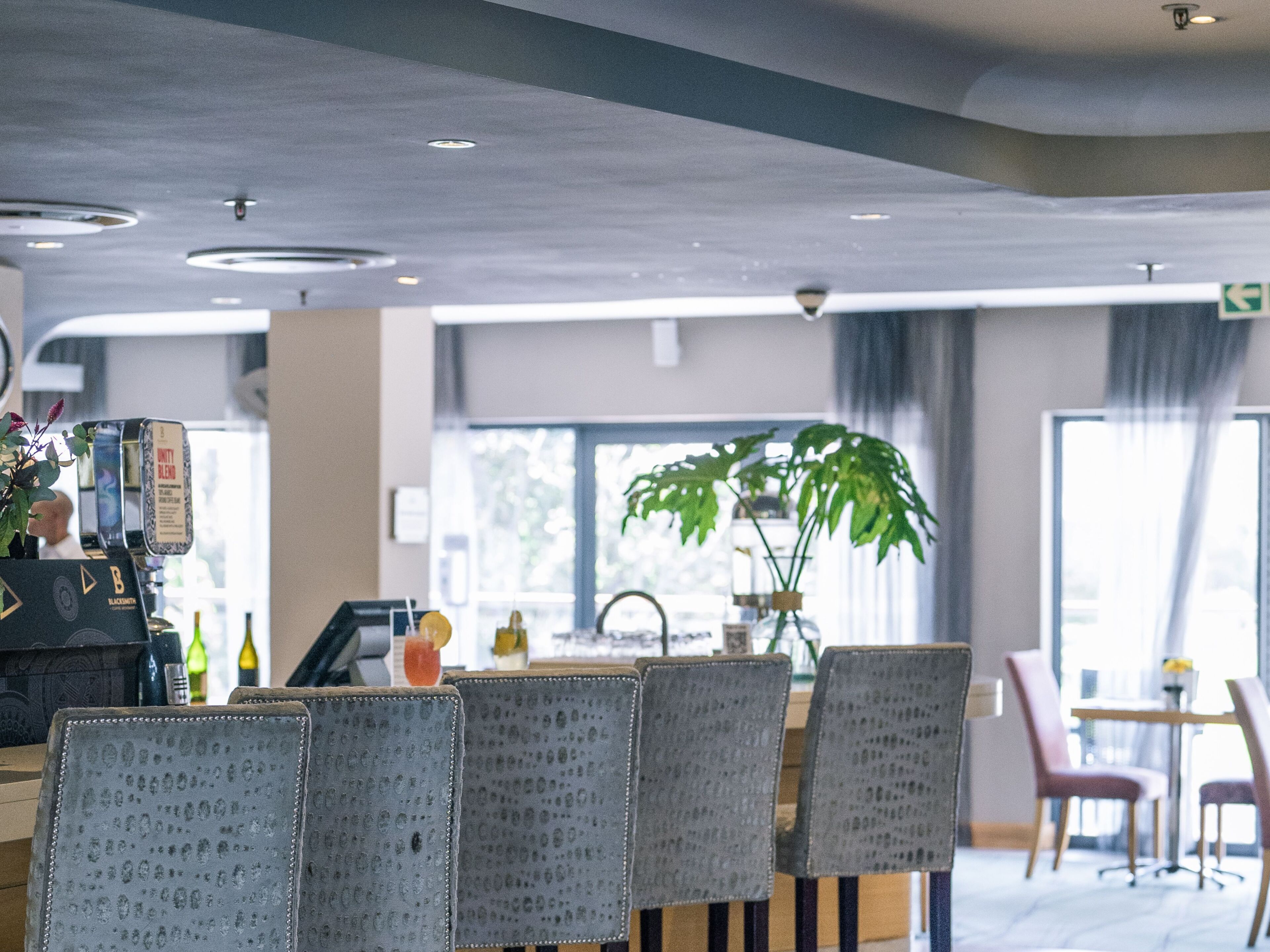 A modern interior with a bar area, seating, and a large window.
