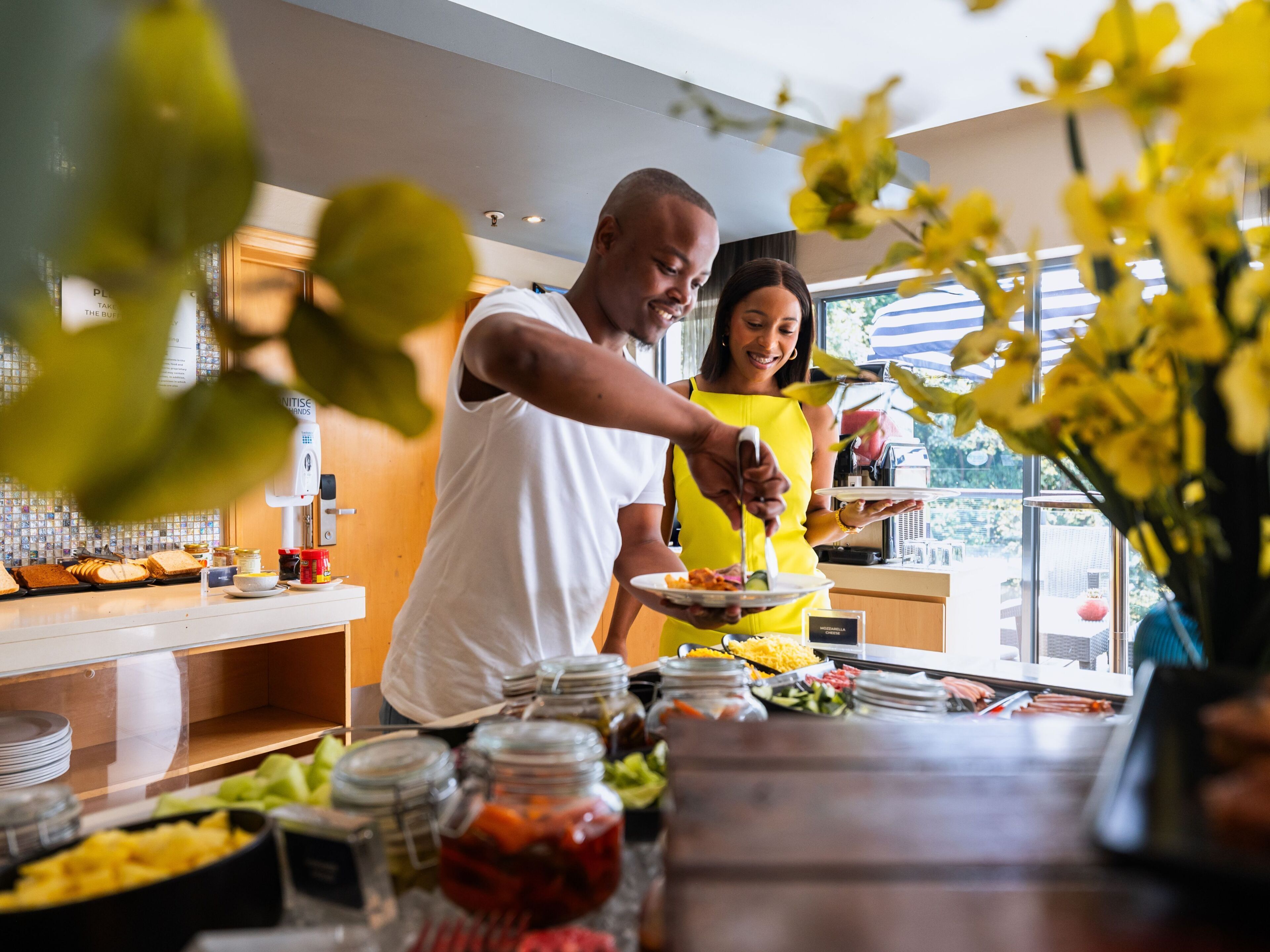 A buffet setup with various food items and a person serving food.