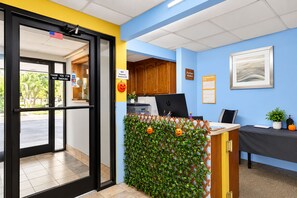 An office reception area with a desk, computer, and a wall-mounted calendar. - Southern Inn Manchester TN I 24 (Manchester)