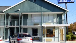 A two-story building with a sign reading "Liberty Inn." There are cars parked in front, and a small awning extends from the building. - Liberty Inn (Waynesboro)