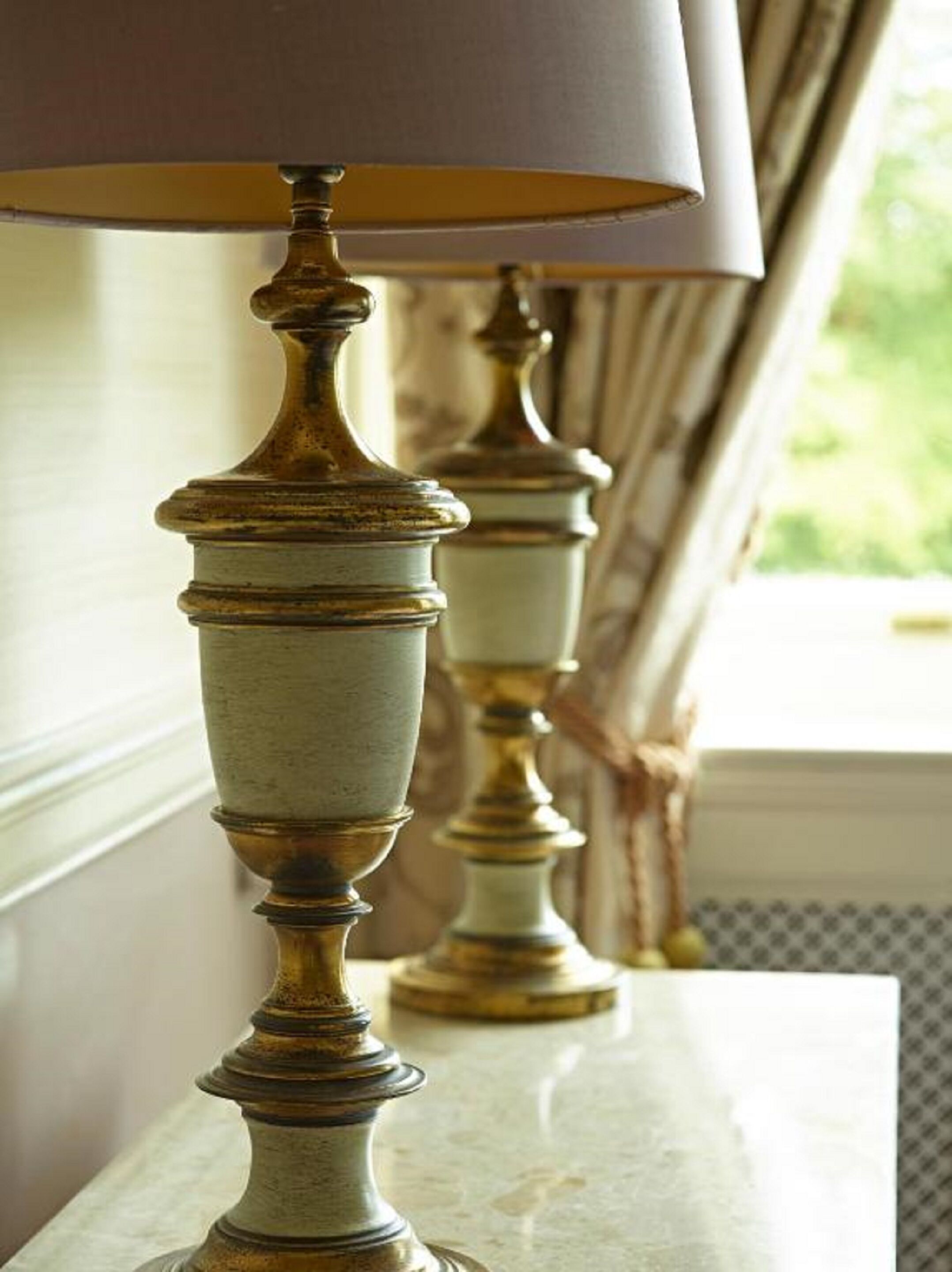 A lamp with a beige shade on a marble surface.