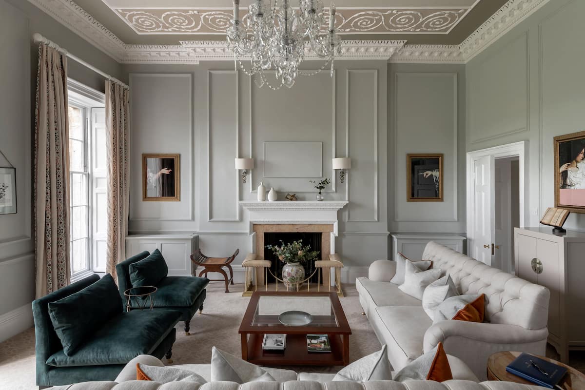 Uma sala de estar espaçosa com lareira, móveis elegantes e um candelabro.