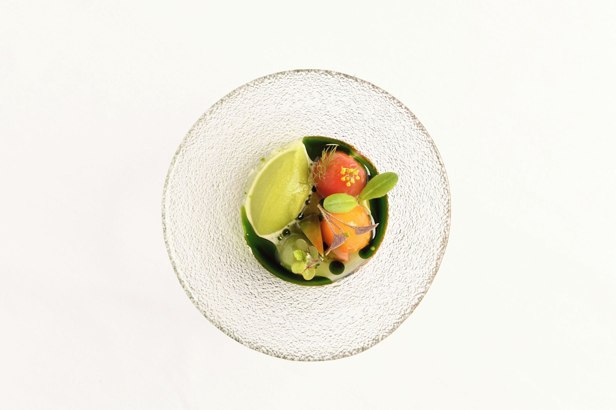 A top-down view of a dish on a textured white plate.
