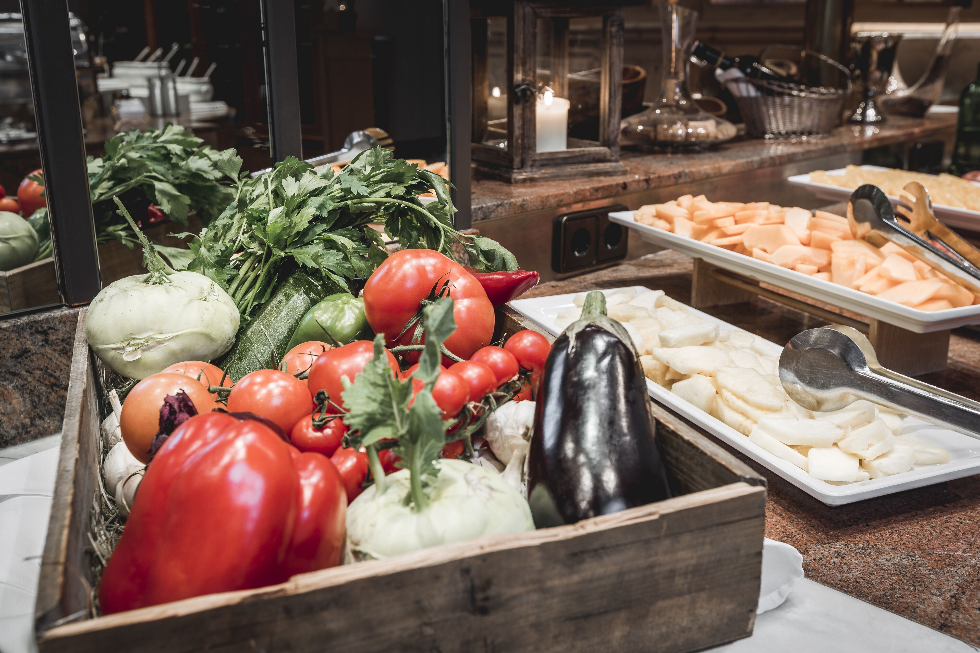 Un bufé con diversas verduras y frutas, como tomates, pepinos y berenjenas.