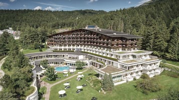 A large hotel with multiple balconies and a swimming pool.