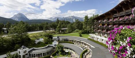 A resort with a pool, outdoor seating, and mountain views.