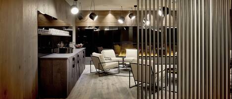 Un interior moderno con área de cocina, asientos y un separador decorativo.