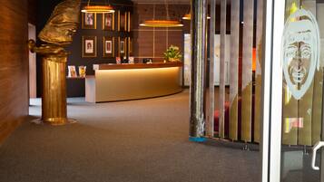 A reception area with a golden statue, a reception desk, framed pictures on the wall, and a modern interior design.