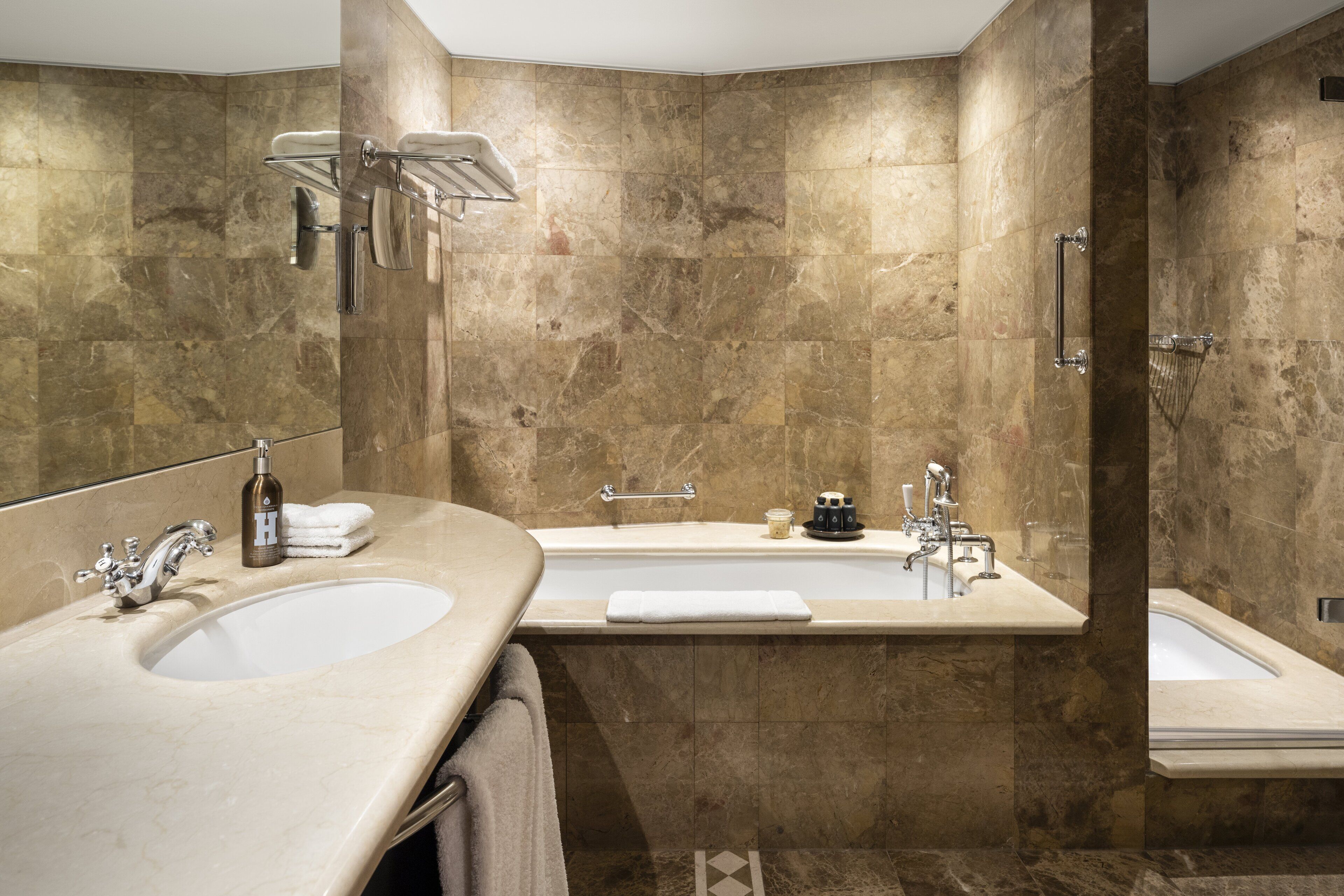Un baño moderno con dos lavamanos, una bañera y una ducha.