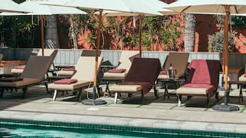 Een buitenzwembad, parasols voor strand/zwembad