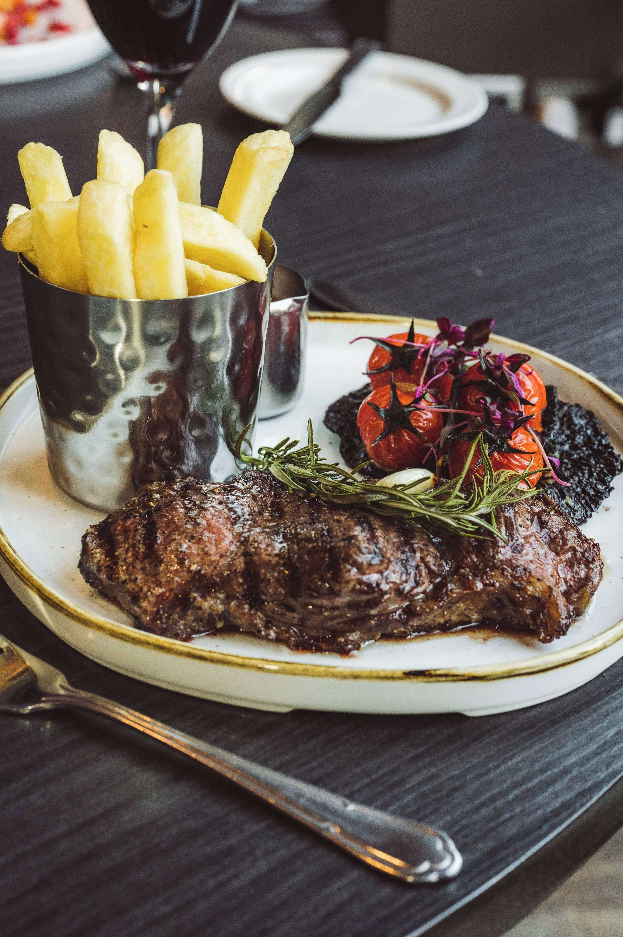 A plate with steak, fries, and a side of vegetables.