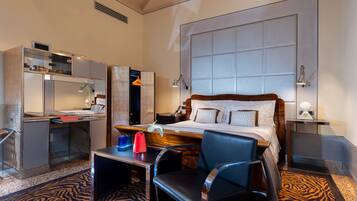 Una habitación de hotel con cama, escritorio, silla y un ventanal grande.