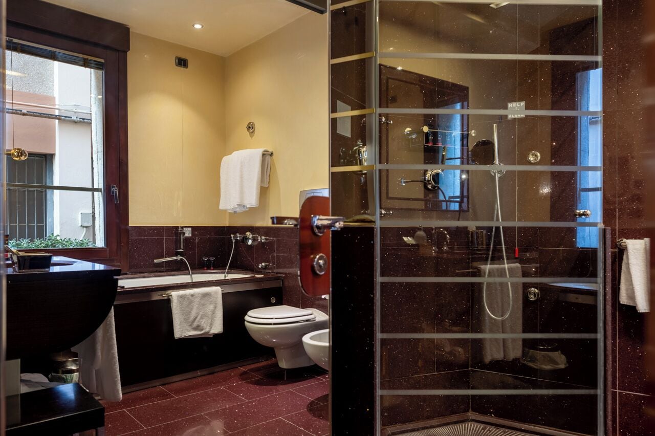 Een moderne badkamer met een douchecabine van glas, een wastafelmeubel en een toilet.
