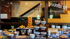 A buffet setup with various food items and a piano in the background.