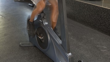 Une salle de sport équipée de matériel d’exercice, notamment un vélo d’appartement et un tapis de course.