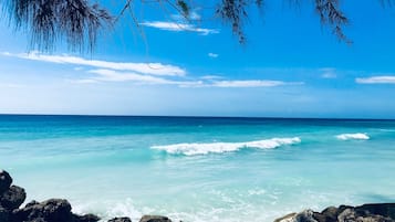 Nära stranden, vit sandstrand, solstolar och parasoller