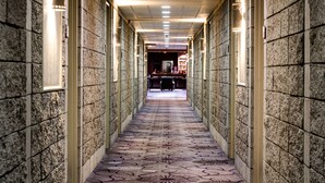 A hallway with patterned carpet, stone walls, and recessed lighting. - Grand Hotel & Conference Centre Calgary Airport, an Ascend Collection Hotel (Calgary)
