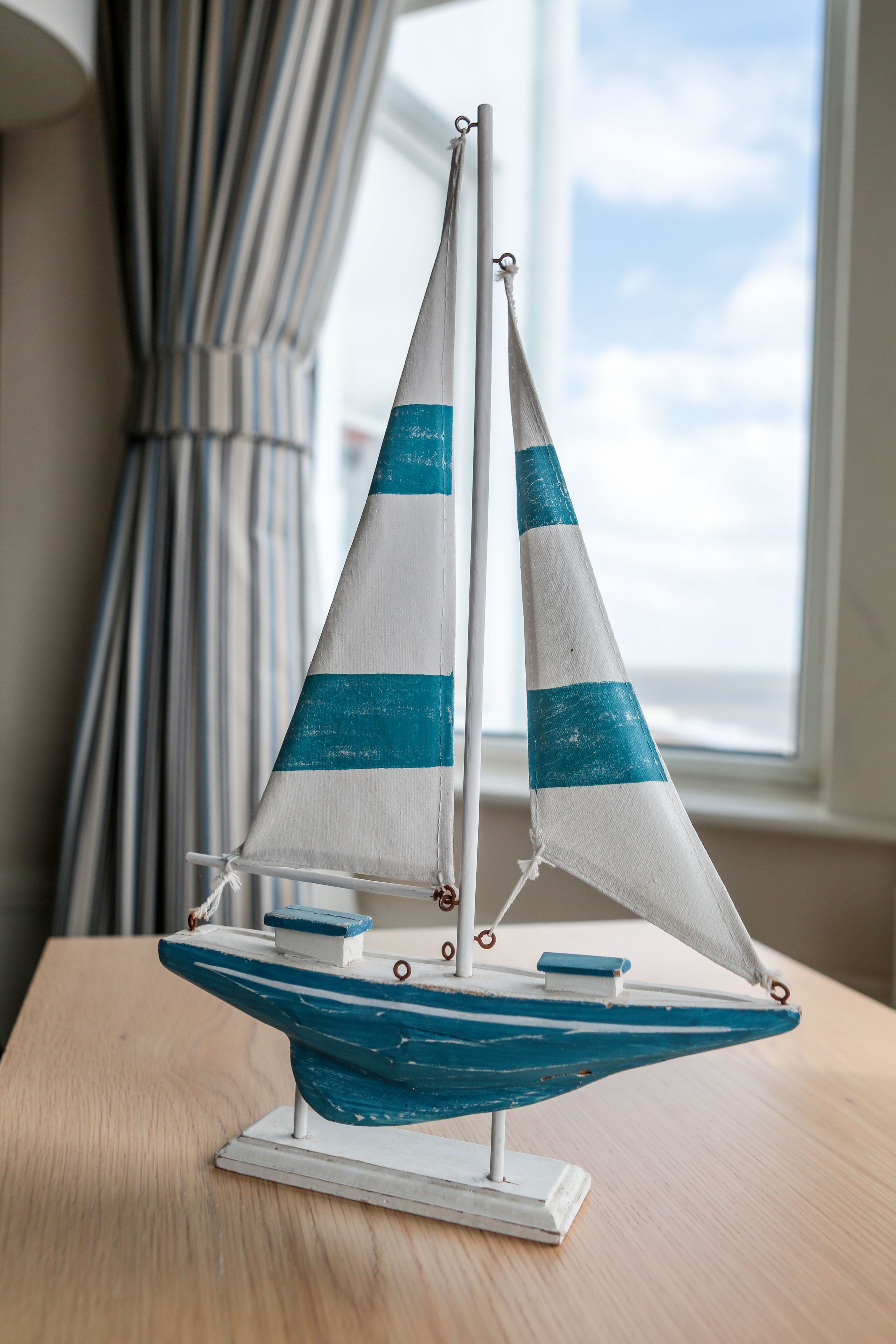A model sailboat on a wooden table.