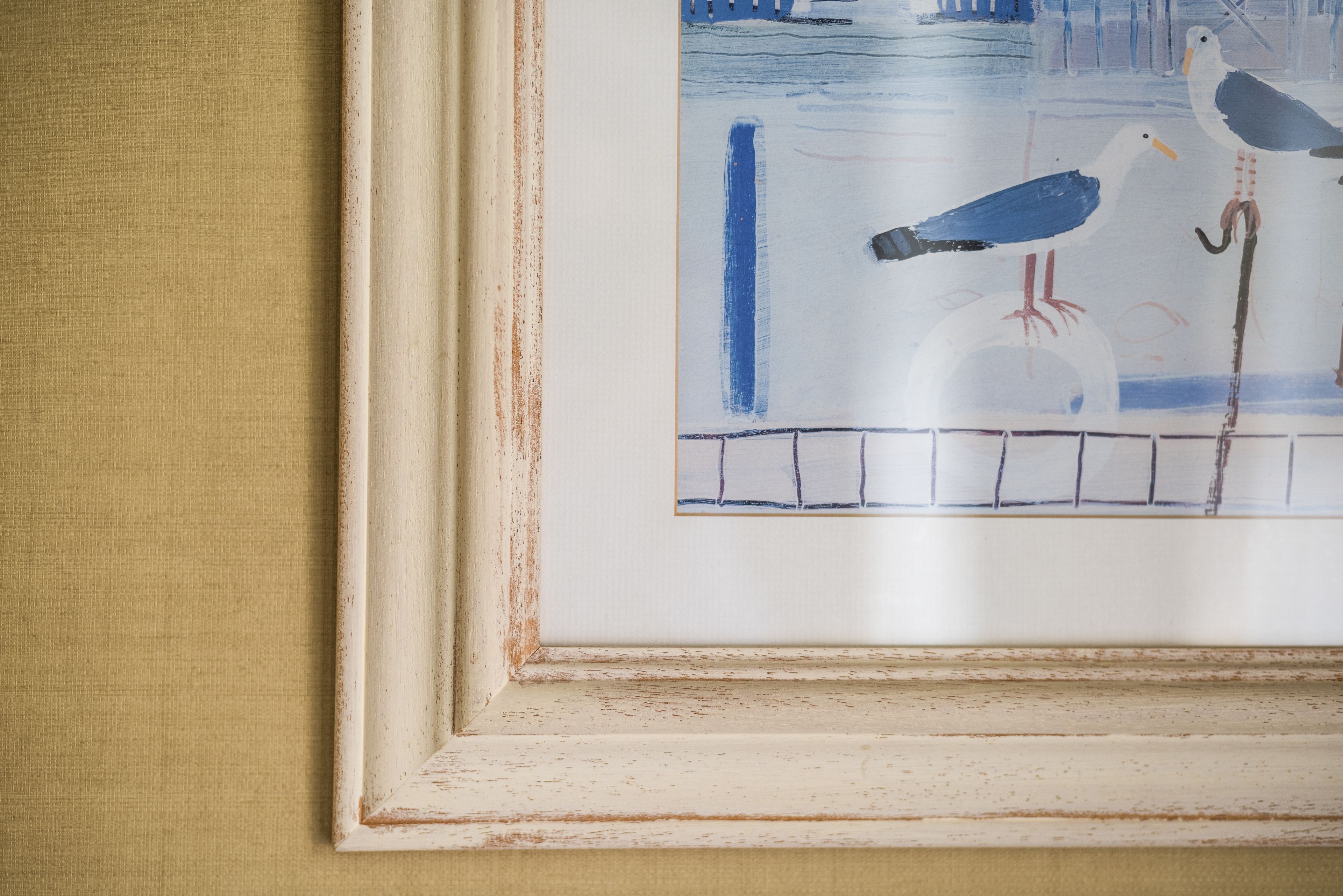 A framed painting of birds on a dock.