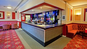 A bar area with a counter, seating, and a patterned carpet. - Britannia Coventry Hill Hotel (Coventry)