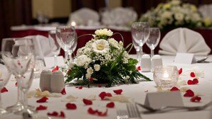 A table set for a formal event with white tablecloths, glassware, and a centerpiece of white flowers. - Britannia Coventry Hill Hotel (Coventry)