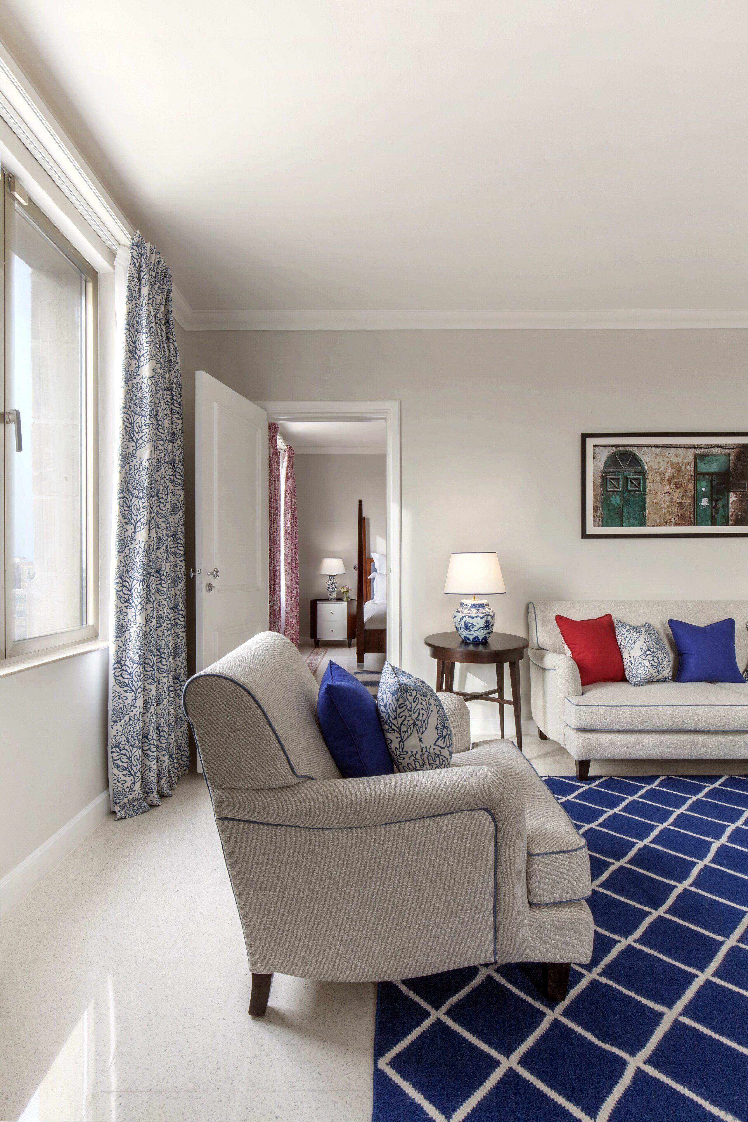A living room with a sofa, a patterned rug, and a lamp.