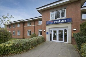 A Travelodge building with a brick facade, a signboard, and a gated entrance. - Travelodge Stonehouse (Stonehouse)