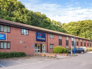 A Travelodge hotel with a brick facade, a visible entrance, and a parking area. - Travelodge Medway M2 (Gillingham)