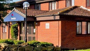 A Travelodge hotel with a brick facade, a signboard, and a well-maintained lawn. - Travelodge Sleaford (Sleaford)