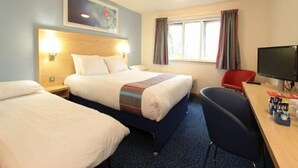 A hotel room with two beds, a desk, a chair, a television, and a window with curtains. - Travelodge Sleaford (Sleaford)