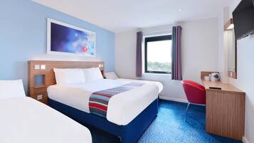 A hotel room with a large bed, a desk, a chair, a TV, and a window with curtains.