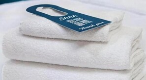 A stack of white towels with a tag that reads 'Shhh... DO NOT STAND Thank you.' - Travelodge Barnsley (Barnsley)
