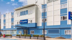 Ett Travelodge-hotell med en blå och vit fasad, många fönster och en skylt som visar att det ligger i London.