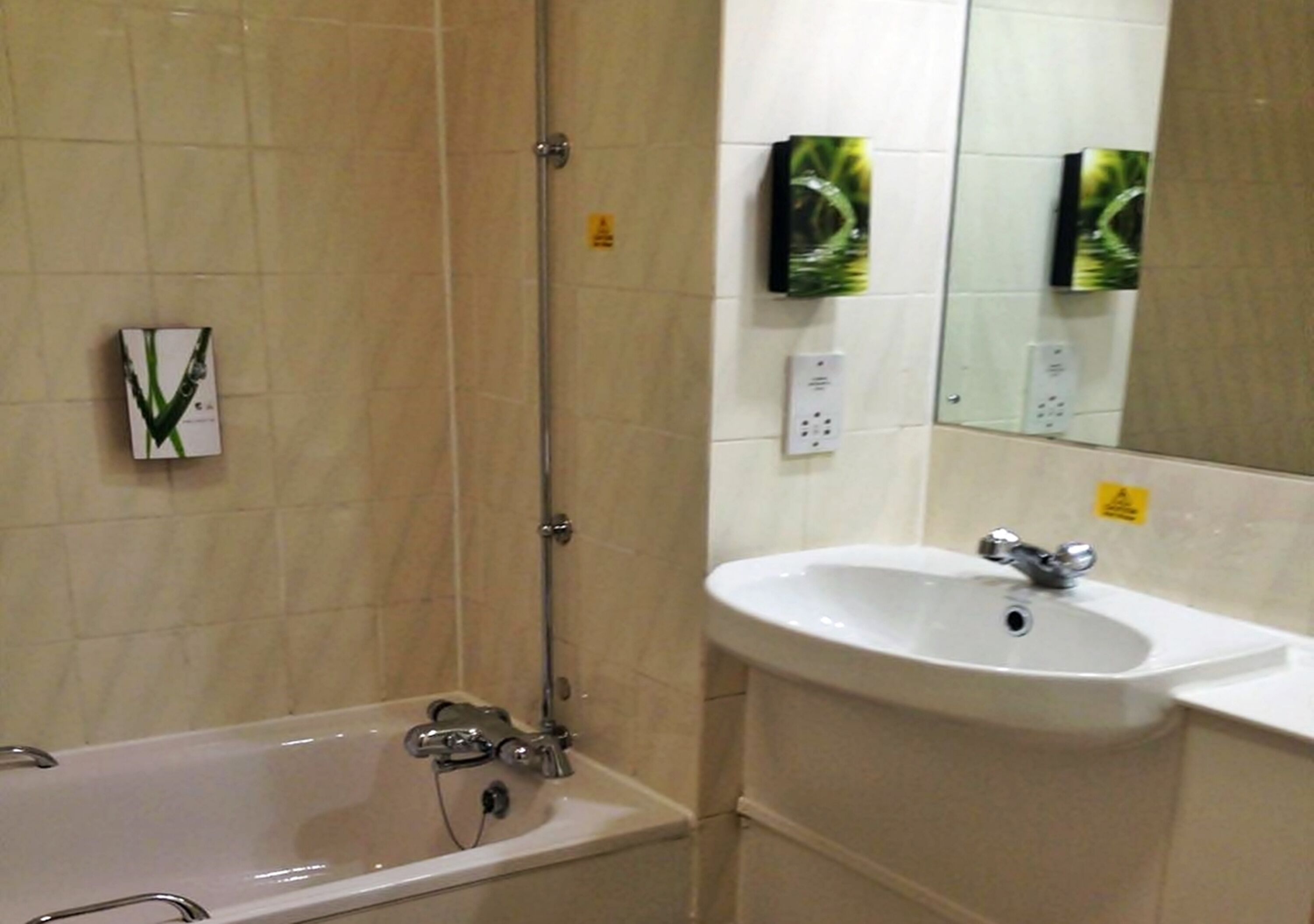 Une salle de bain avec une baignoire, un lavabo et un miroir.