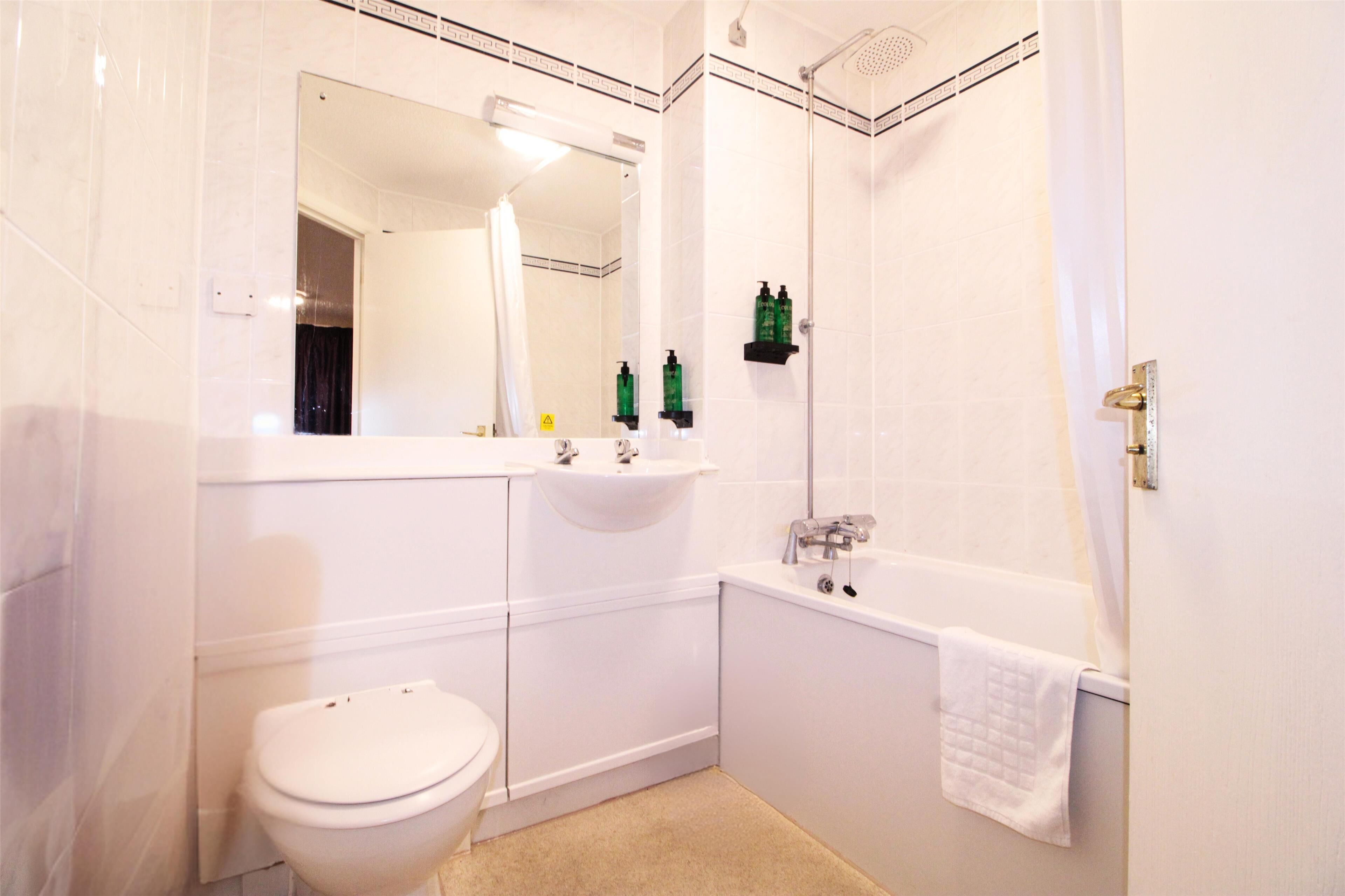 Une salle de bain avec des toilettes, un lavabo et une baignoire.