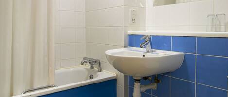 A bathroom with a bathtub, sink, and toilet.