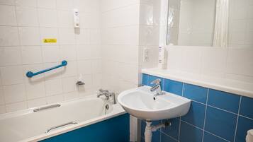 Un baño con una bañera blanca, un lavabo y un inodoro.