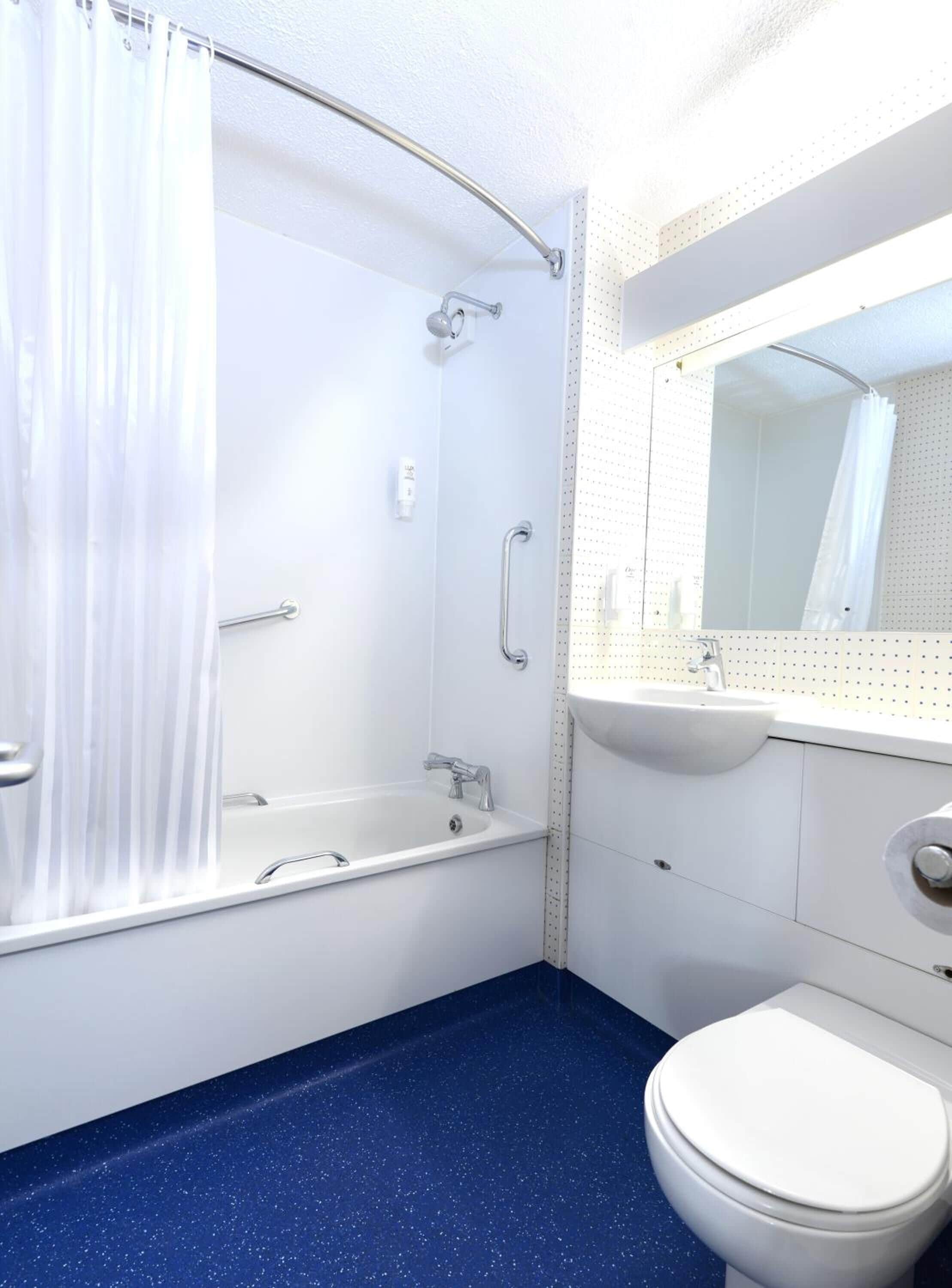 A bathroom with a bathtub, shower, toilet, and sink.