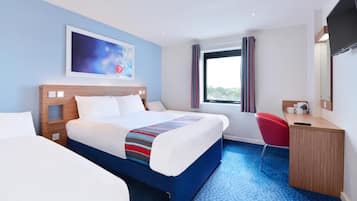 Ein Hotelzimmer mit einem großen Bett, einem Schreibtisch, einem Stuhl, einem Fernseher und einem Fenster mit Vorhängen.
