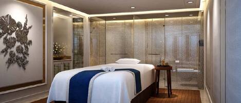 A modern hotel room with a large bed, a glass partition, and a decorative wall piece.