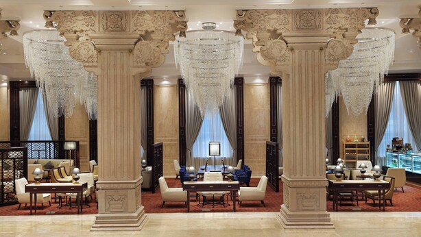 A luxurious lobby with ornate columns, a chandelier, and a seating area with tables and chairs. - Sheraton Grand Pune Bund Garden Hotel (Pune)