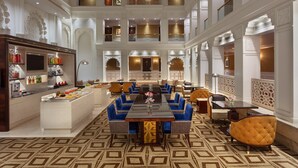 A spacious, multi-level hotel lobby with a central dining area, multiple seating options, and a well-lit, ornate interior. - Sheraton Grand Pune Bund Garden Hotel (Pune)