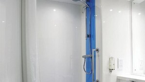 Ein modernes Badezimmer mit einer Duschkabine, einem weißen Waschbecken und einem Handtuchhalter.