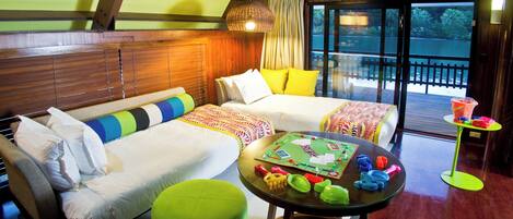A cozy room with a sofa, a green ottoman, and a table with a board game.