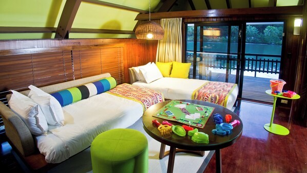 A cozy room with a sofa, a green ottoman, and a table with a board game. - Holiday Inn Resort Vanuatu by IHG (Port Vila)
