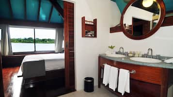Un baño con dos lavamanos, un espejo y una ventana con vista al agua.