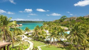 A tropical resort with a swimming pool, palm trees, and a view of the ocean. - Holiday Inn Resort Vanuatu by IHG (Port Vila)