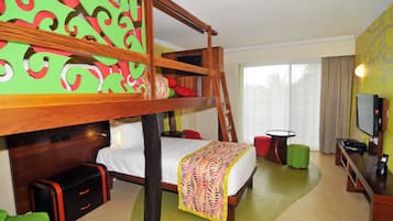 Habitación de hotel con literas, un escritorio con computadora, televisión y un amplio ventanal con cortinas.